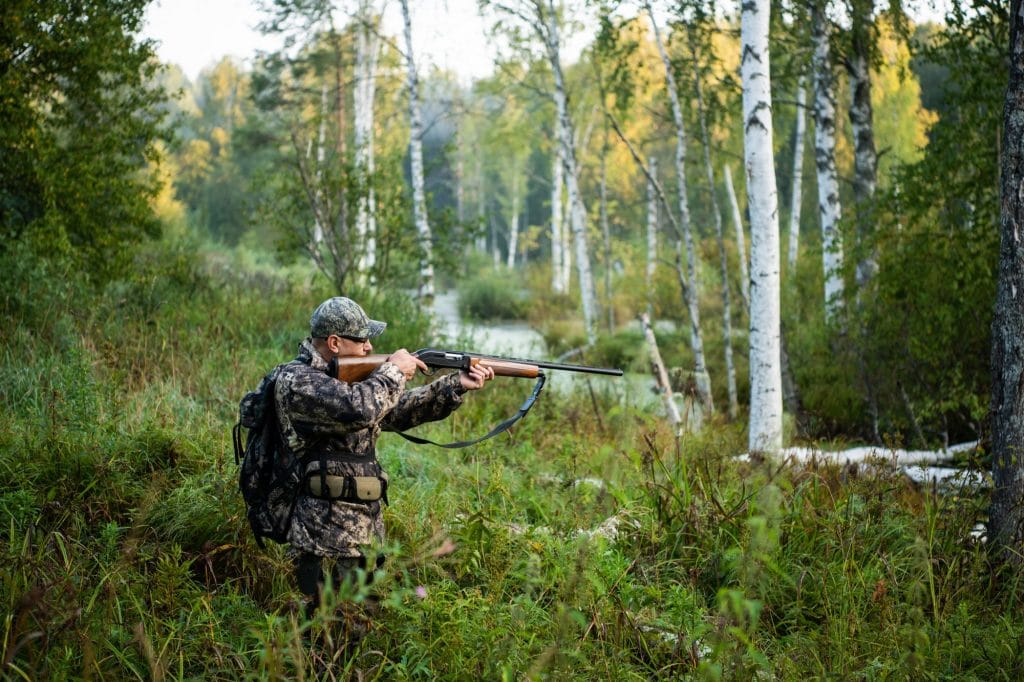 Hunter aiming with weapon at the outdoor hunting